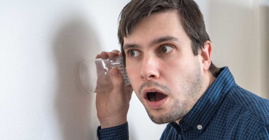 Curious man is listening through the wall